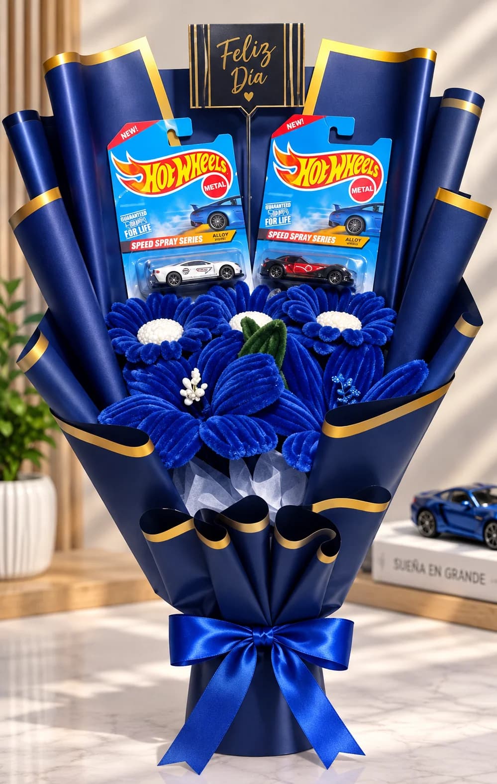 Ramo con dos carros Hot Wheels, flores azules y envoltura azul con dorado
